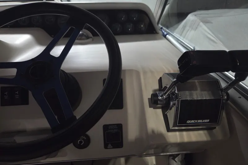 Slide: The Image of 1996 Sea Ray 290 Sundancer helm with steering wheel and Quicksilver throttle controls. - 10