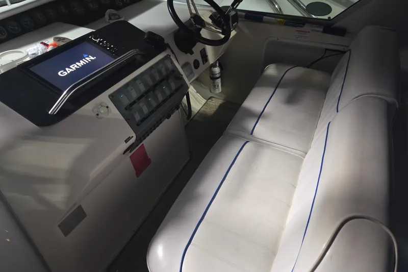 Slide: The Image of 1996 Sea Ray 290 Sundancer cockpit with Garmin navigation system and white seating. - 11