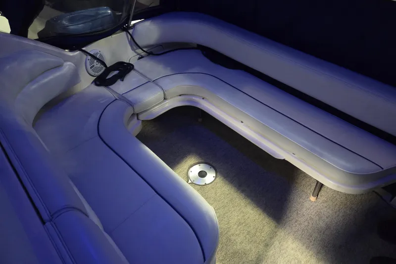 Slide: The Image of 1996 Sea Ray 290 Sundancer interior with curved seating and ambient lighting. - 17