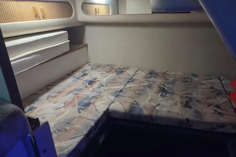 Slide: The Image of 1996 Sea Ray 290 Sundancer cabin interior with patterned upholstery and storage compartments. - 25