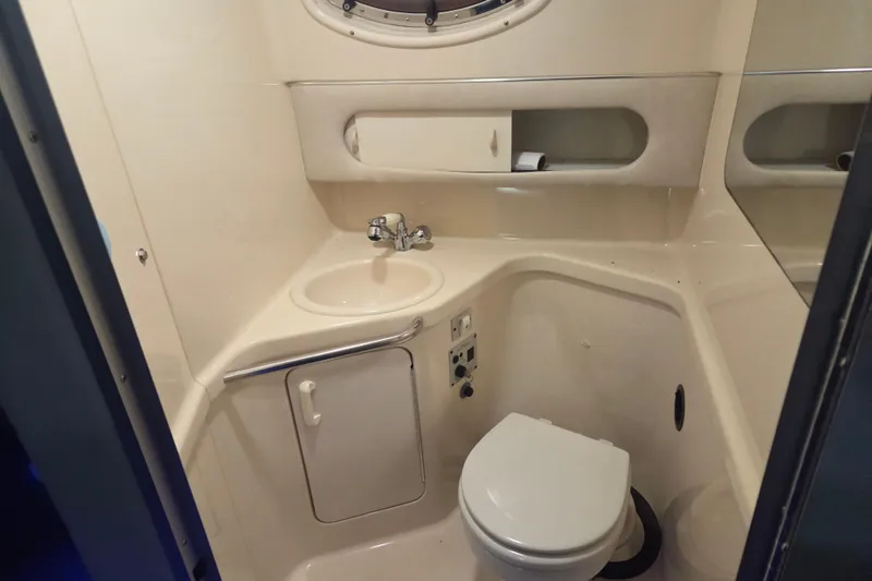 Slide: The Image of 1996 Sea Ray 290 Sundancer bathroom with sink, toilet, and storage compartments. - 27