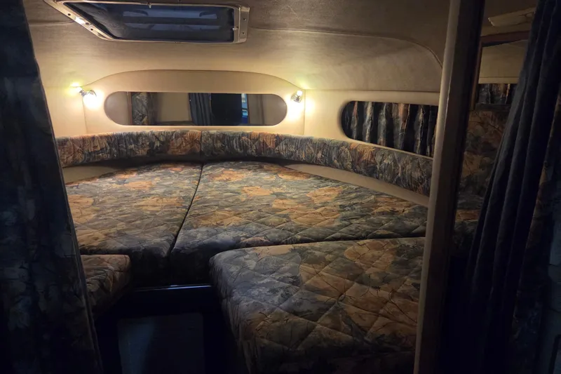 Slide: The Image of 1996 Sea Ray 290 Sundancer cabin interior with patterned bedding and ambient lighting. - 28