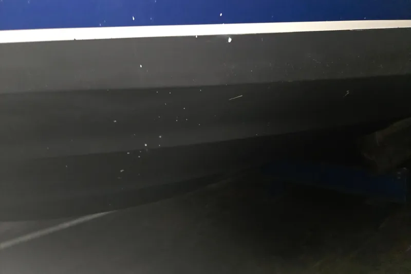 Slide: The Image of 1996 Sea Ray 290 Sundancer boat hull, black and blue, close-up view. - 38