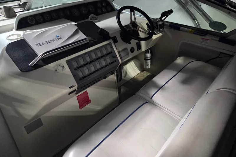 Slide: The Image of 1996 Sea Ray 290 Sundancer helm with Garmin navigation and white seating. - 4
