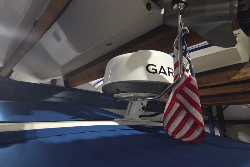 Slide: The Image of 1996 Sea Ray 290 Sundancer with radar and American flag in a boathouse. - 8