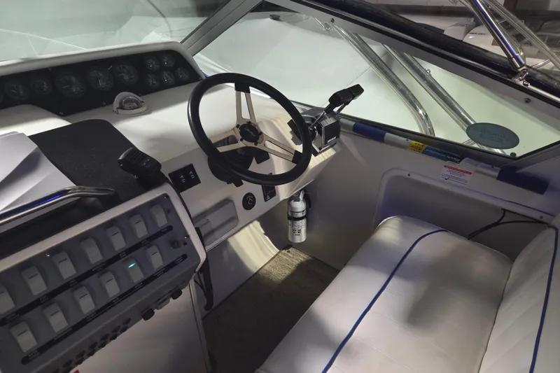 Slide: The Image of 1996 Sea Ray 290 Sundancer helm with steering wheel and control panel. - 9