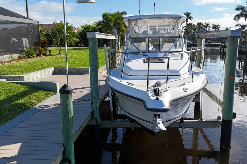 Slide: The Image of 2008 Century 2600 Walk-Around boat docked by a waterfront with lush greenery. - 10
