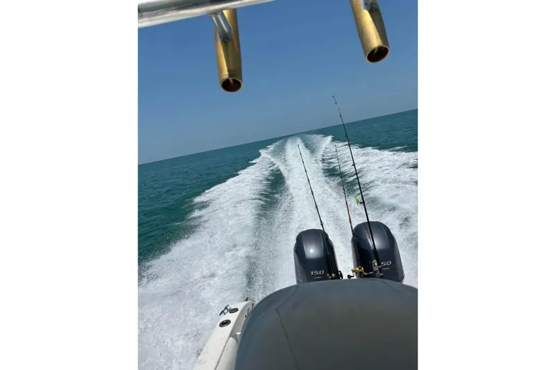 Slide: The Image of 2008 Century 2600 Walk-Around boat with Yamaha engines on a lift by a canal. - 4