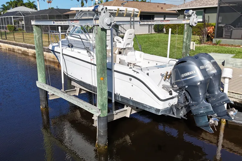 Slide: The Image of 2008 Century 2600 Walk-Around boat with Yamaha engines on a lift by a canal. - 7