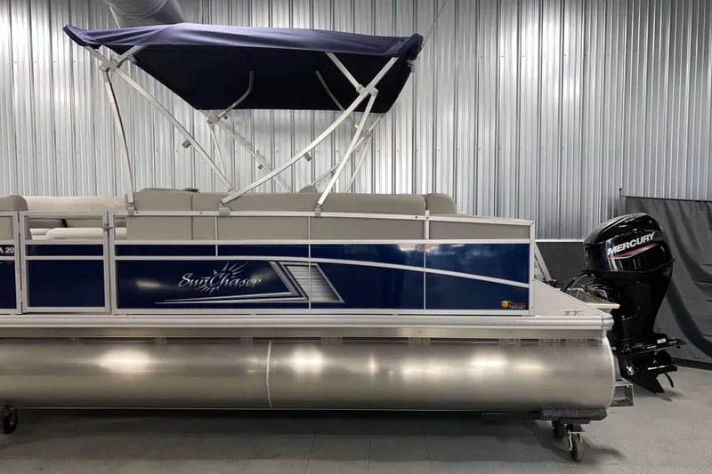 Slide: The Image of 2025 SunChaser Vista 20 CRB pontoon boat with Mercury outboard motor in a showroom. - 17