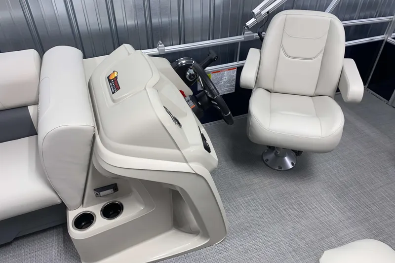 Slide: The Image of 2025 SunChaser Vista 20 CRB boat interior with beige captain's chair and helm controls. - 6