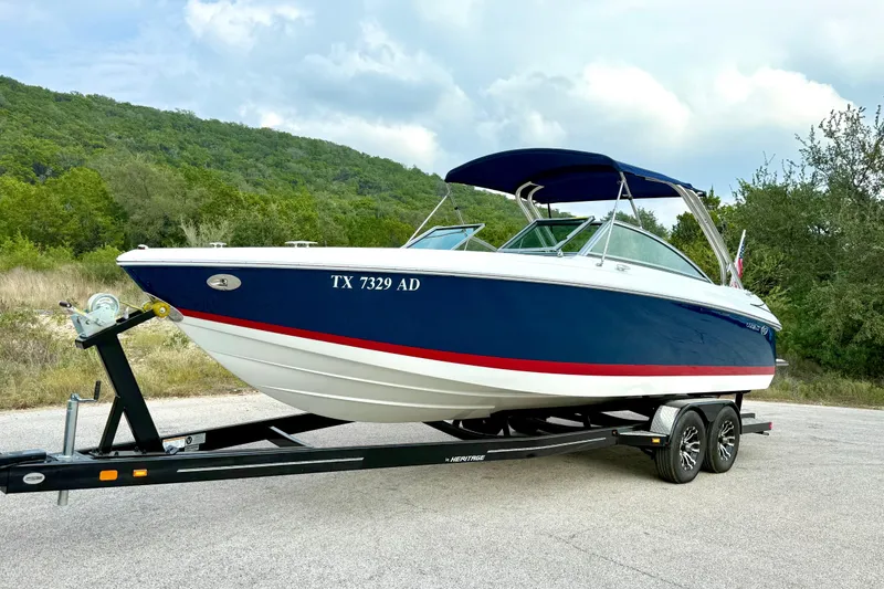 Slide: The Image of 2006 Cobalt 272 boat on trailer, blue hull, red stripe, scenic background. - 11
