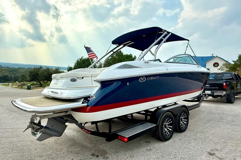 Slide: The Image of 2006 Cobalt 272 boat on trailer, blue and white design, parked outdoors. - 16