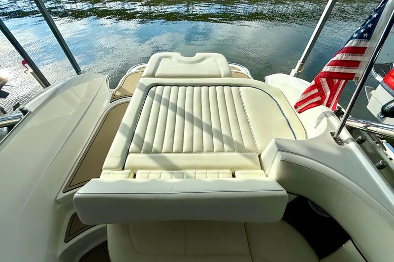 Slide: The Image of Luxury seating on a 2006 Cobalt 272 boat with American flag, docked by water. - 24
