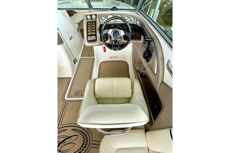 Slide: The Image of 2006 Cobalt 272 boat interior with steering wheel and beige seating. - 32