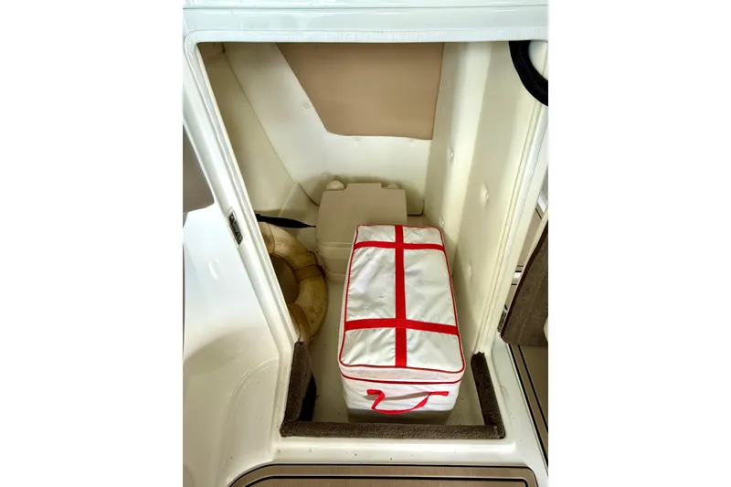 Slide: The Image of 2006 Cobalt 272 boat storage compartment with life preserver and red-striped bag. - 35