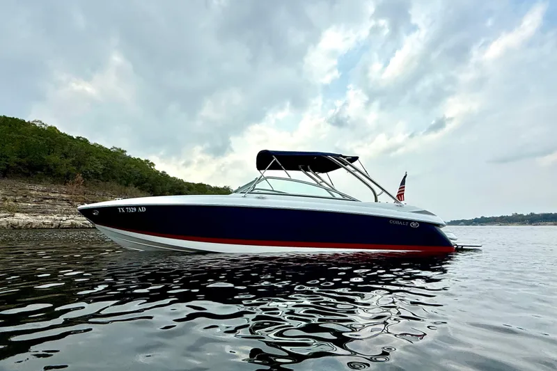 Slide: The Image of 2006 Cobalt 272 boat on calm water with cloudy sky backdrop. - 4