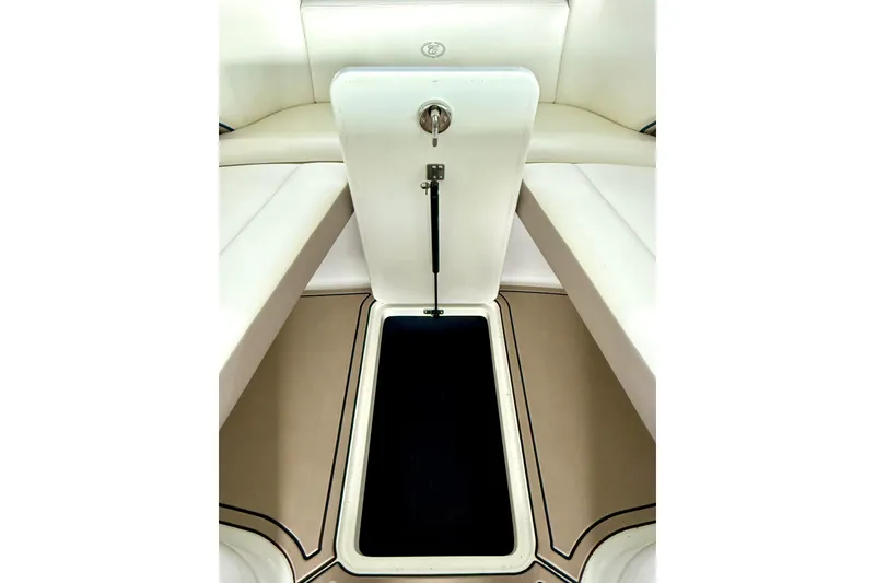 Slide: The Image of 2006 Cobalt 272 boat interior storage compartment with white seating and beige flooring. - 42