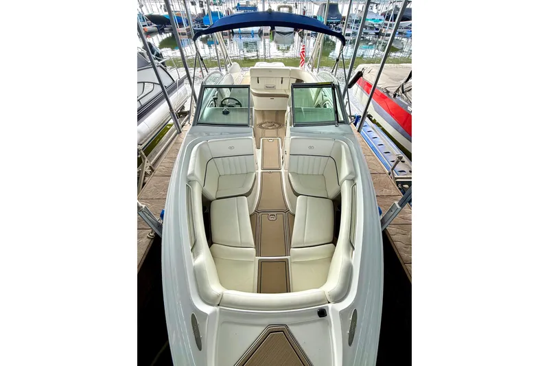 Slide: The Image of 2006 Cobalt 272 boat with white seating and blue canopy, docked at a marina. - 44