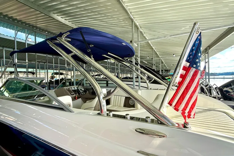 Slide: The Image of 2006 Cobalt 272 boat with American flag, docked under covered marina. - 50