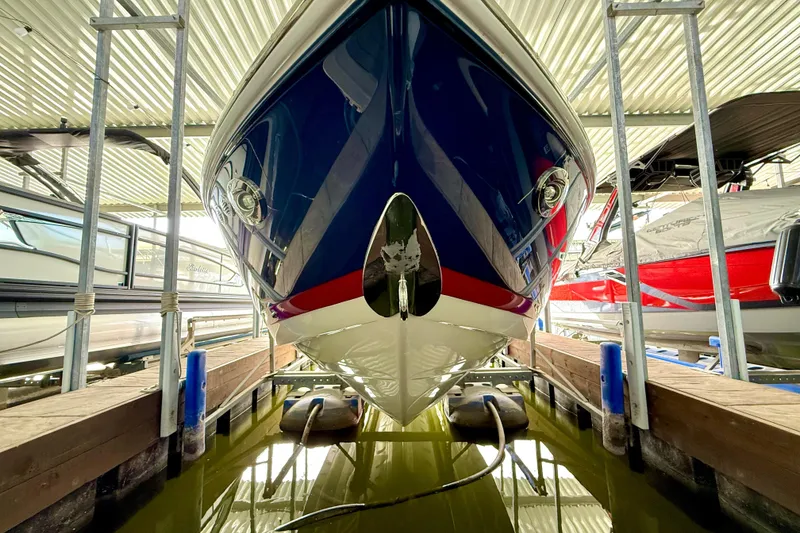 Slide: The Image of 2006 Cobalt 272 boat docked in a covered marina, viewed from the front. - 51
