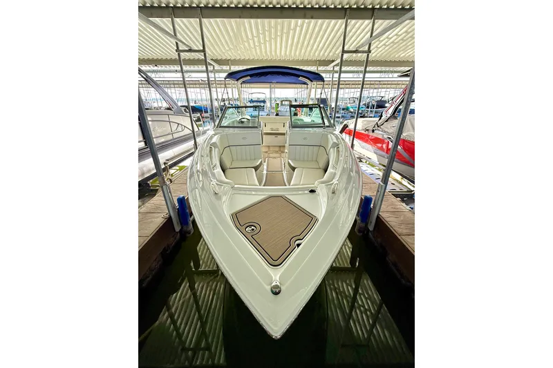 Slide: The Image of 2006 Cobalt 272 boat docked under a covered marina, showcasing sleek design and spacious seating. - 52