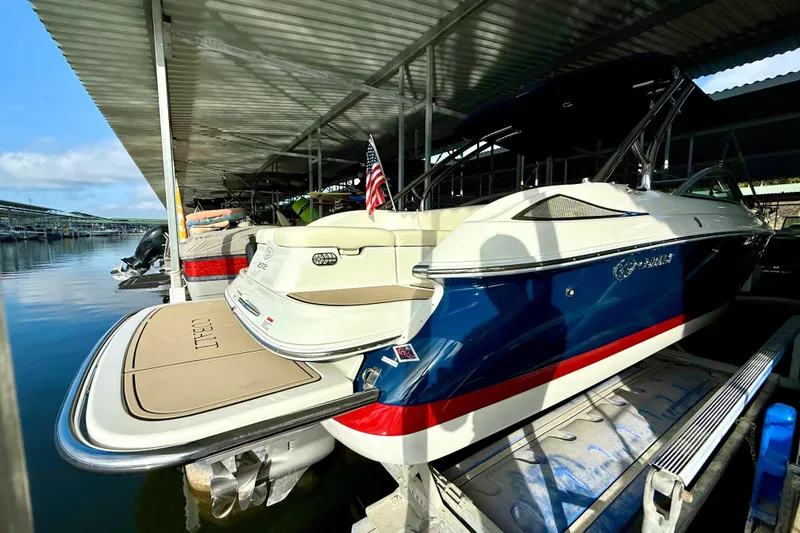 Slide: The Image of 2006 Cobalt 272 boat docked under a covered marina with American flag. - 54