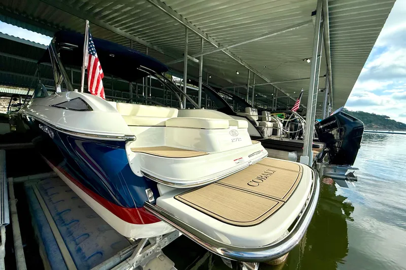 Slide: The Image of 2006 Cobalt 272 boat docked under a covered marina with American flag. - 55