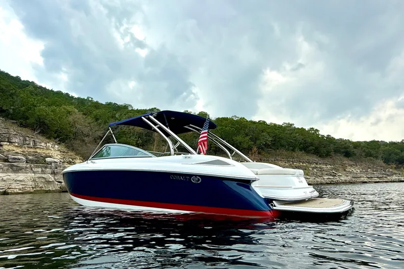 Slide: The Image of 2006 Cobalt 272 boat on a lake, surrounded by rocky cliffs and greenery. - 7
