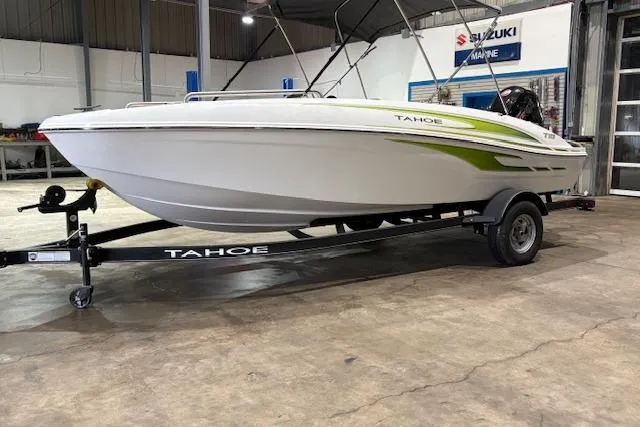 The Image of 2024 Tahoe T18 boat on trailer in showroom, featuring sleek design and green accents. - 0