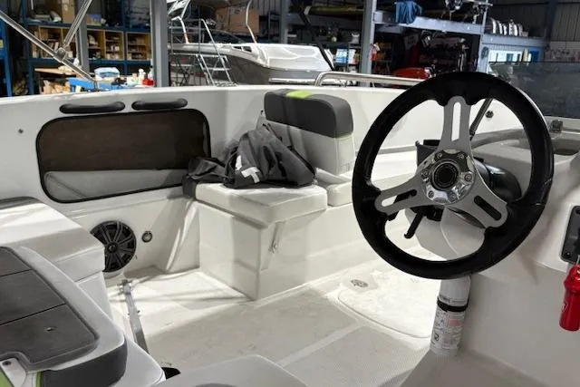 Slide: The Image of Interior of a 2024 Tahoe T18 boat featuring steering wheel and seating area. - 5