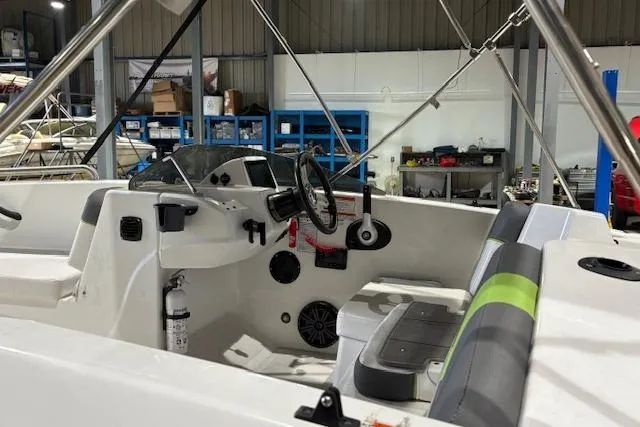 Slide: The Image of 2024 Tahoe T18 boat interior with steering wheel and seating in a workshop setting. - 8