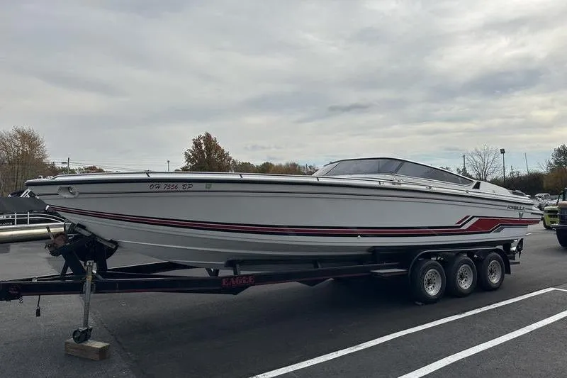 Slide: The Image of 1989 Formula 292 SR-1 speedboat on trailer, parked outdoors under cloudy sky. - 12