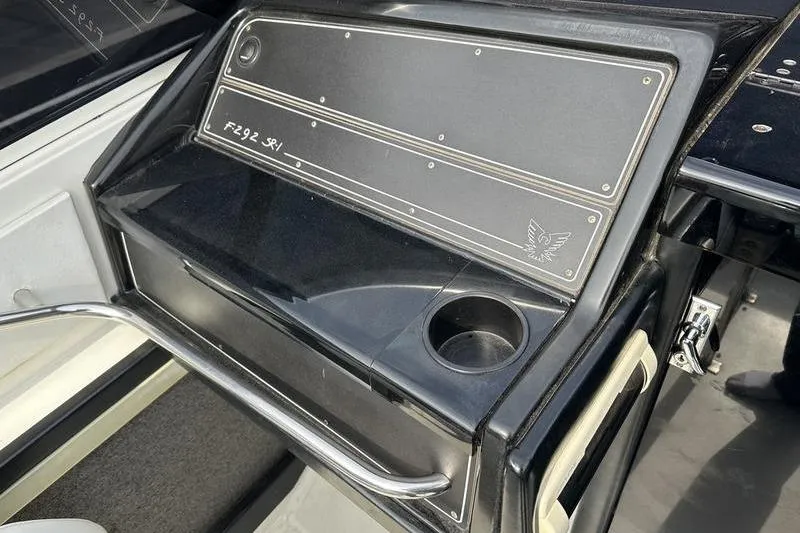 Slide: The Image of 1989 Formula 292 SR-1 boat dashboard with cup holder and sleek black design. - 47