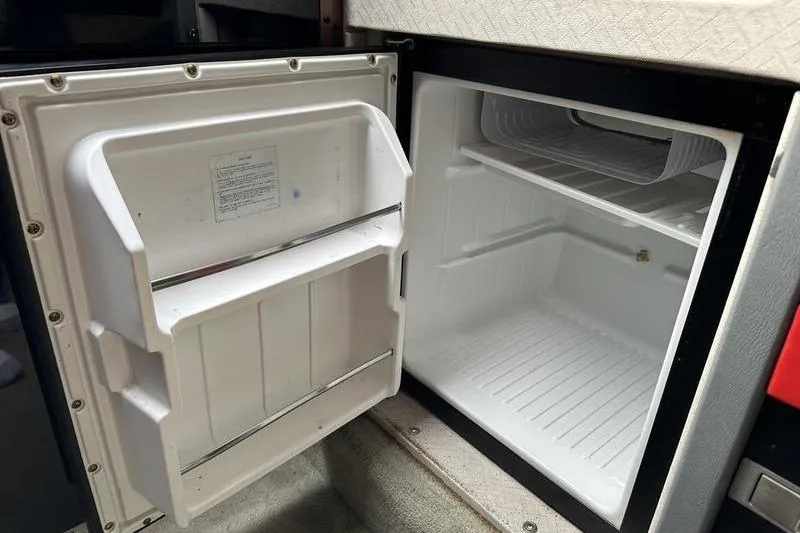 Slide: The Image of Open refrigerator inside 1989 Formula 292 SR-1 boat, showcasing interior storage space. - 60