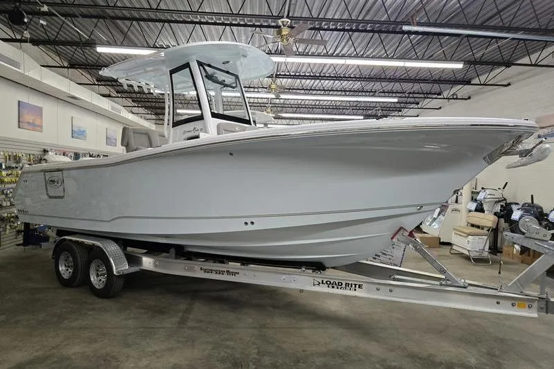 The Image of 2026 Sea Hunt Gamefish 25 boat on trailer in showroom. - 1