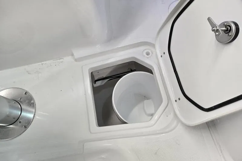 Slide: The Image of 2026 Sea Hunt Gamefish 25 boat storage compartment with open hatch and bucket. - 12