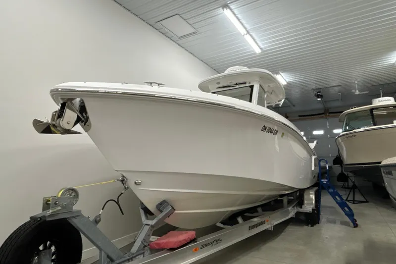 Slide: The Image of 2023 Everglades 285 Center Console boat on trailer in indoor storage. - 1