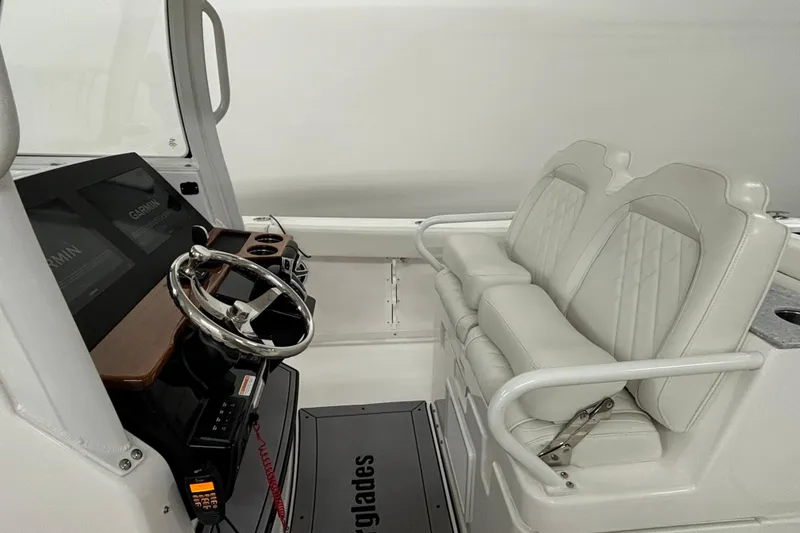 Slide: The Image of 2023 Everglades 285 Center Console boat interior with steering wheel and dual seats. - 10