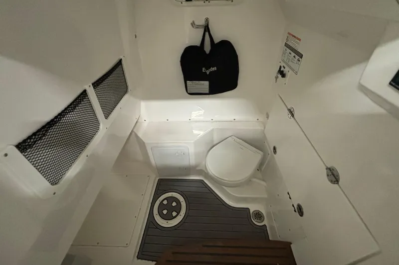 Slide: The Image of 2023 Everglades 285 Center Console boat interior with toilet and storage compartments. - 22