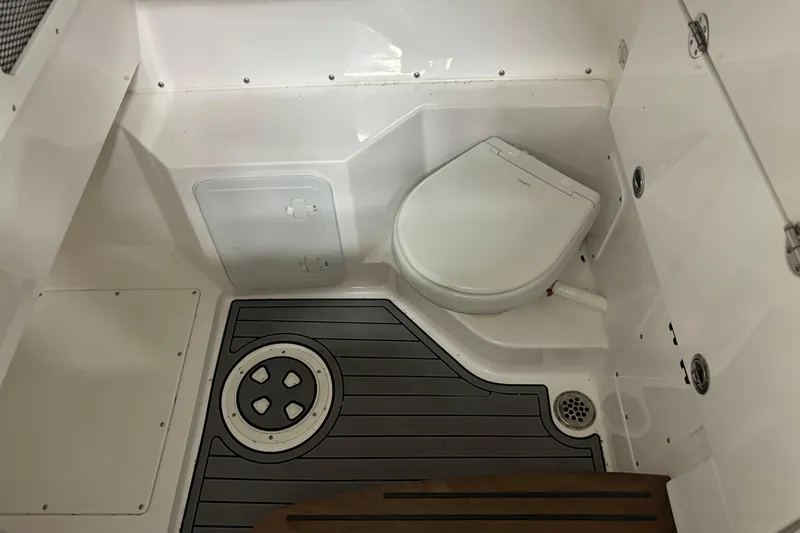 Slide: The Image of 2023 Everglades 285 Center Console boat interior with modern marine toilet and flooring. - 23