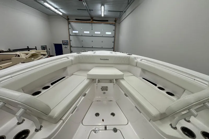 Slide: The Image of 2023 Everglades 285 Center Console boat interior with white seating in a garage. - 26