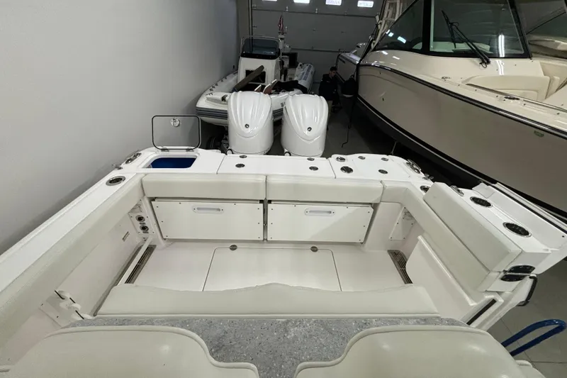 Slide: The Image of 2023 Everglades 285 Center Console boat interior with dual engines in a showroom. - 3