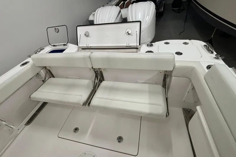 Slide: The Image of 2023 Everglades 285 Center Console boat interior with white seating and storage compartments. - 5