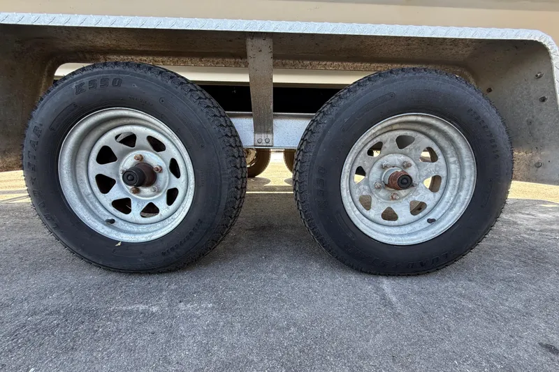 Slide: The Image of Trailer wheels of a 2006 Hydra-Sports Lightning 212 CC boat on pavement. - 12