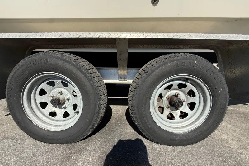 Slide: The Image of Trailer wheels of a 2006 Hydra-Sports Lightning 212 CC boat on pavement. - 13