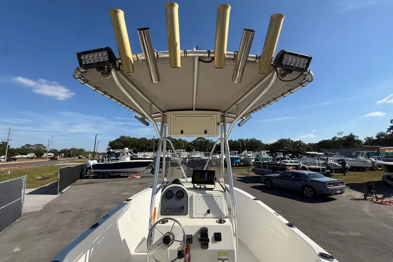 Slide: The Image of 2006 Hydra-Sports Lightning 212 CC boat with T-top and rod holders in a marina. - 17