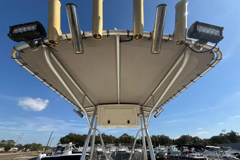 Slide: The Image of 2006 Hydra-Sports Lightning 212 CC boat with T-top and rod holders under clear sky. - 22