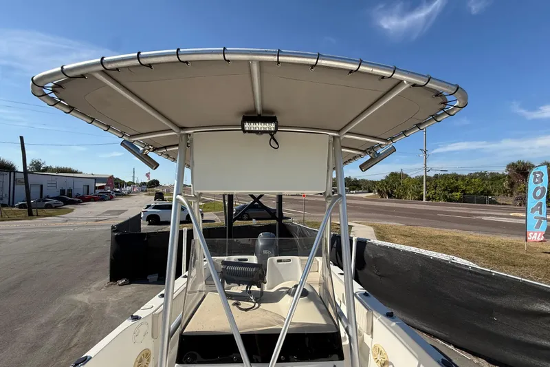 Slide: The Image of 2006 Hydra-Sports Lightning 212 CC boat with T-top, parked near a boat sale sign. - 58