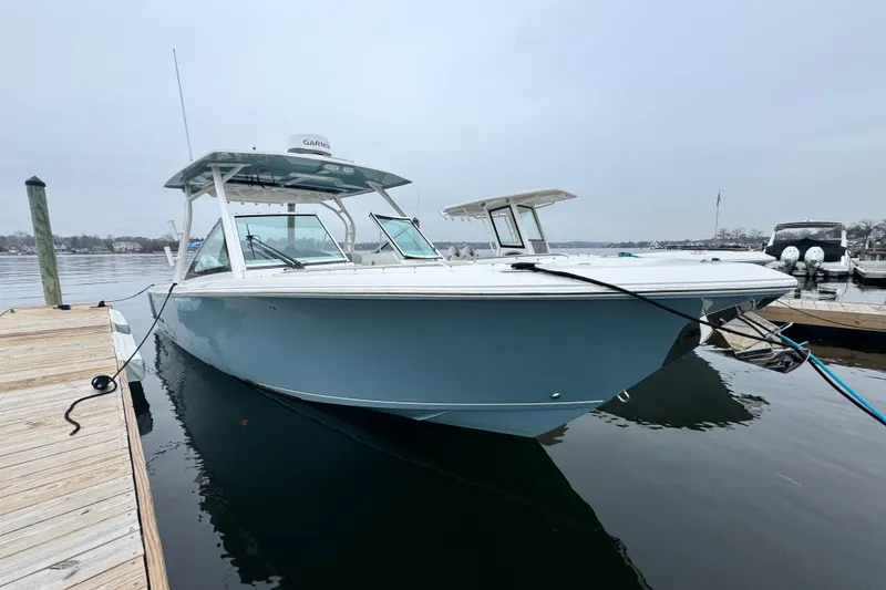 Slide: The Image of 2025 Sailfish 276 DC boat on calm water at sunset, featuring dual Mercury engines. - 1